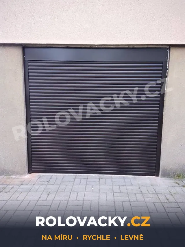 Tmavá rolovací vrata na garáži se zámkovou dlažbou