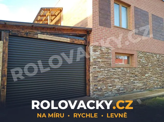 Tmavá rolovací vrata po montáži u kamenné fasády